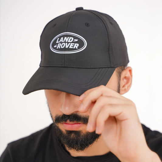 Man wearing a black cap with Land Rover logo on a white background