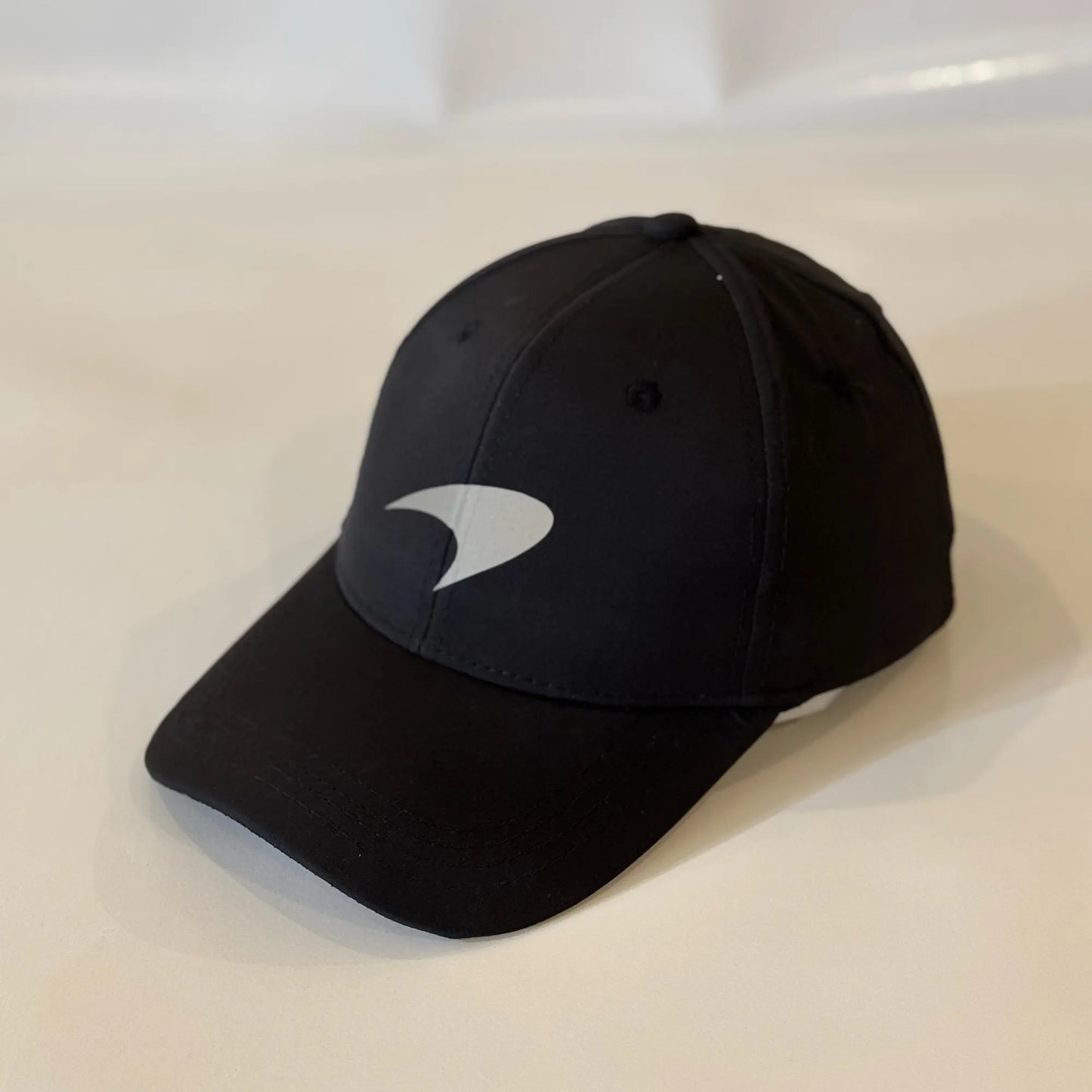 A black snapback cap with the Mclaren logo on the front.