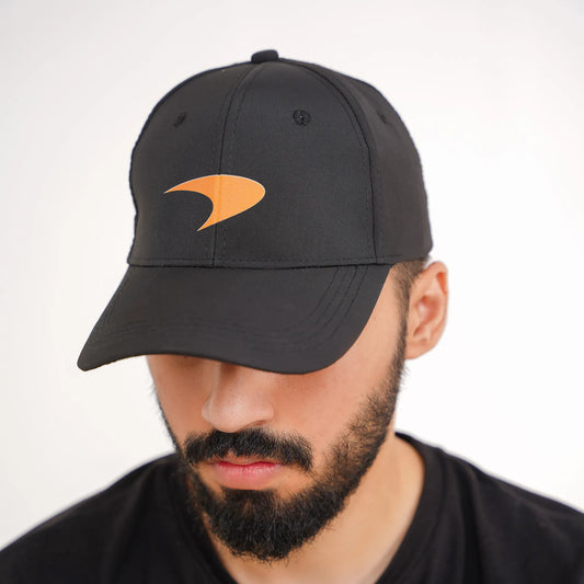 Man wearing a black cap with an orange logo on a white background