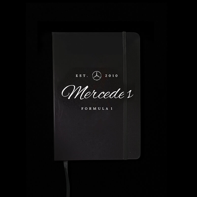 Black notebook with Mercedes Formula 1 branding on a black background