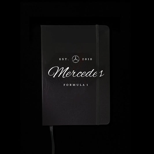 Black notebook with Mercedes Formula 1 branding on a black background