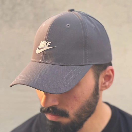Man wearing a gray and brown Nike cap against a plain background.