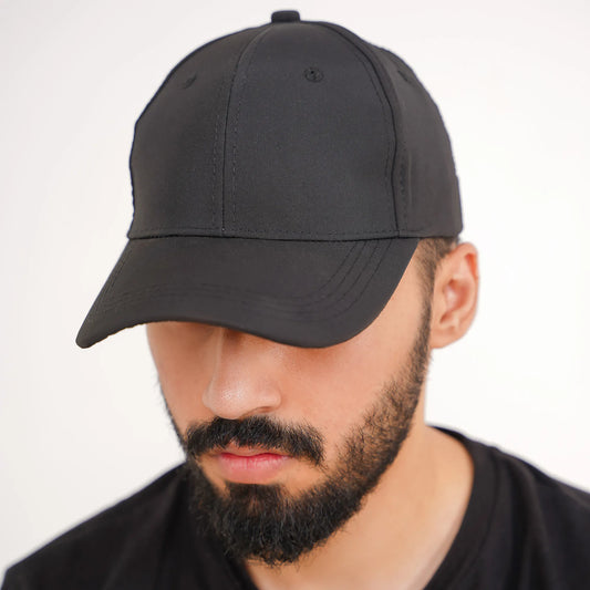 Man wearing a black baseball cap against a white background