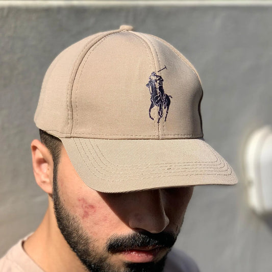 Beige cap with logo worn by a person against a neutral background