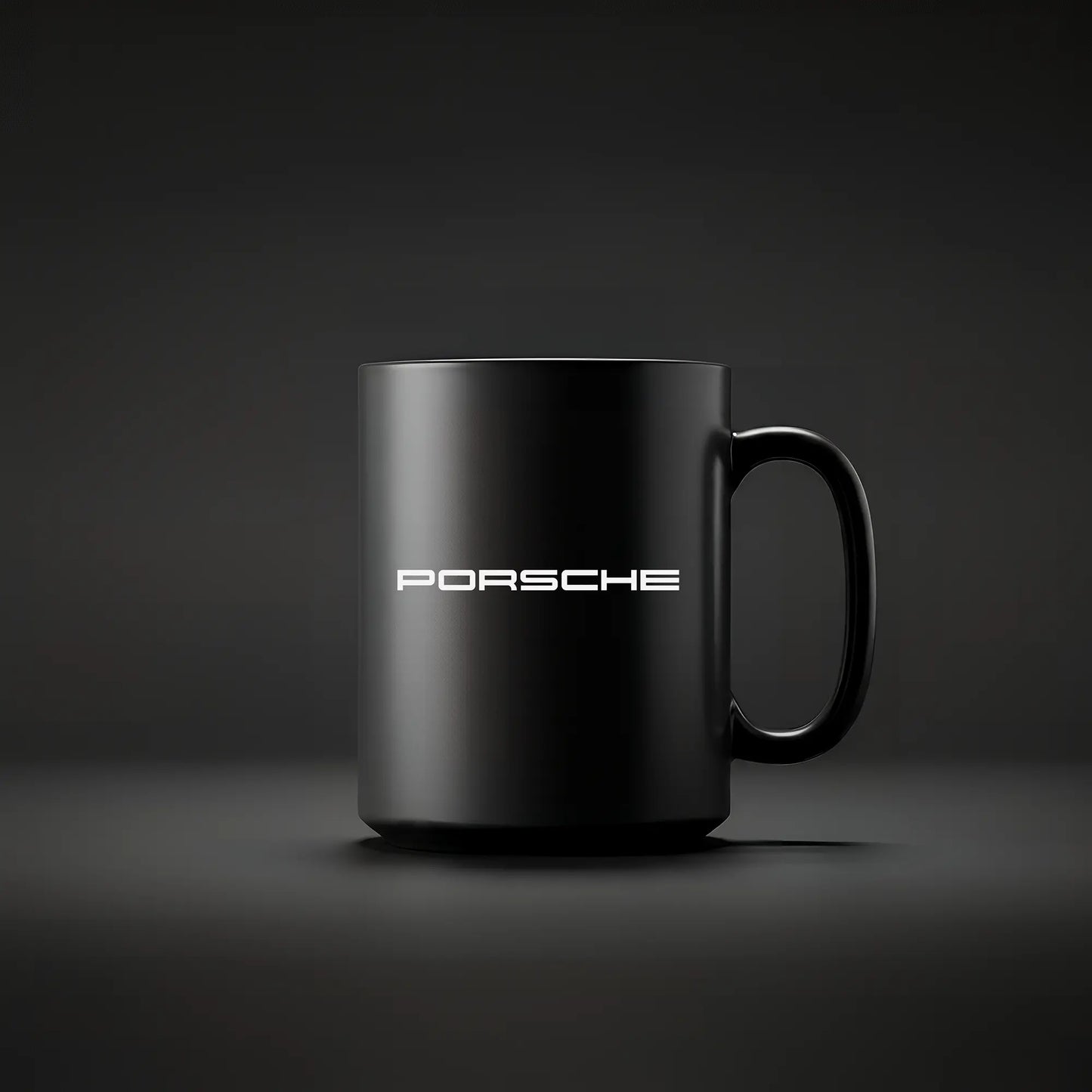 A black ceramic mug with the Porsche logo and the word 'PORSCHE' printed in white on the side, displayed against a dark background.