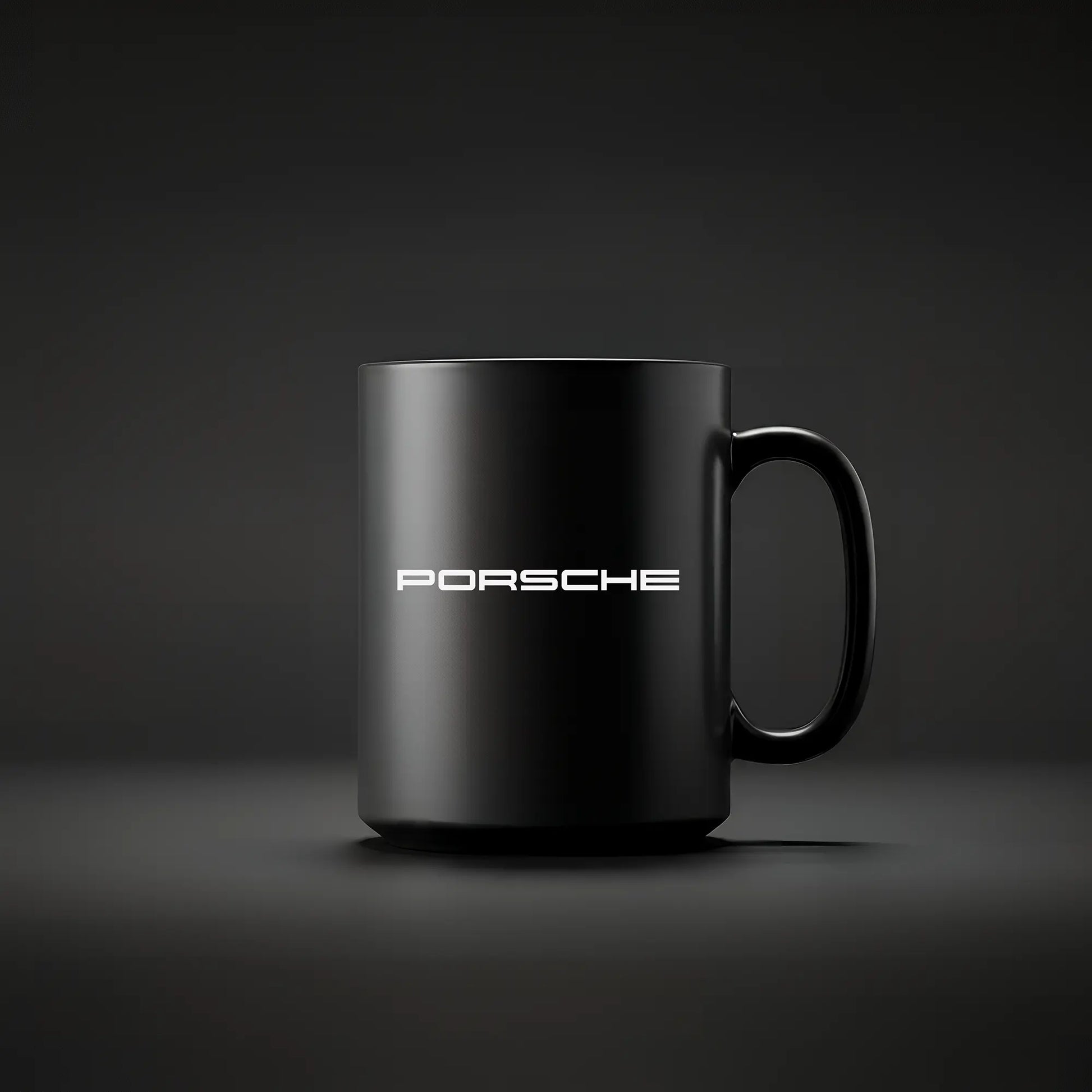 A black ceramic mug with the Porsche logo and the word 'PORSCHE' printed in white on the side, displayed against a dark background.