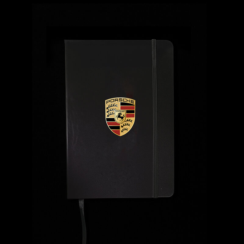 Black notebook with Porsche logo on a black background