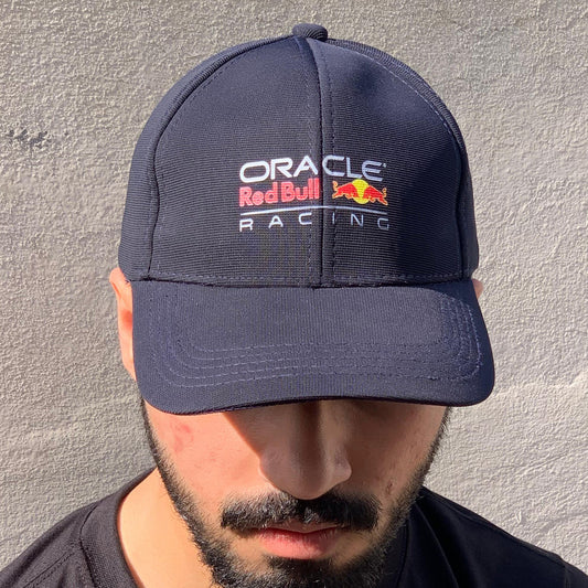A person wearing a navy baseball cap with the 'Oracle Red Bull Racing' logo in white and red.