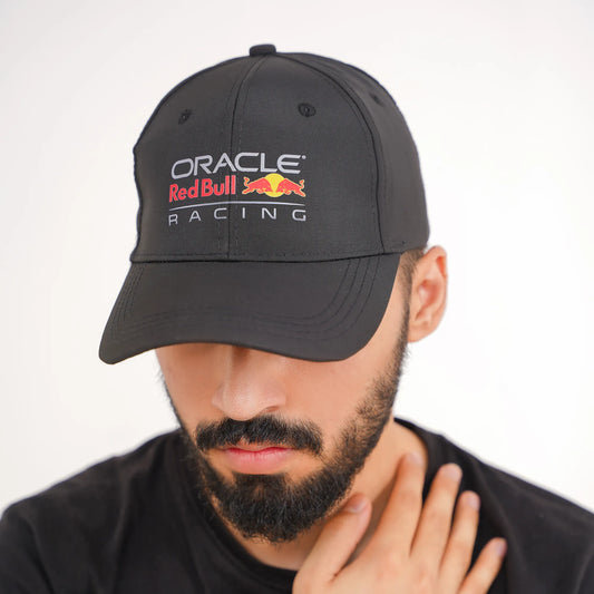 Man wearing a black Oracle Red Bull Racing cap against a white background