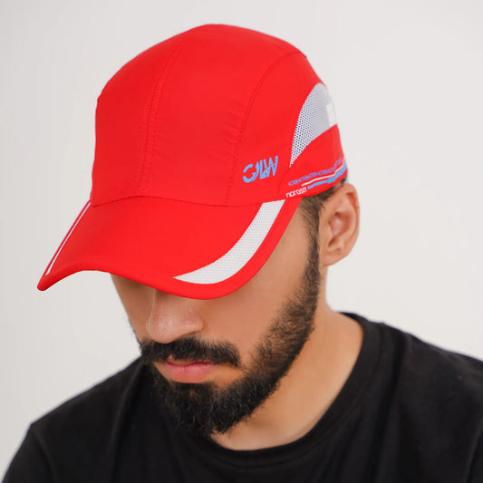 Person wearing a red cap with branding on a plain background