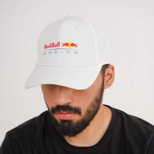 Person wearing a white Red Bull Racing cap on a plain background