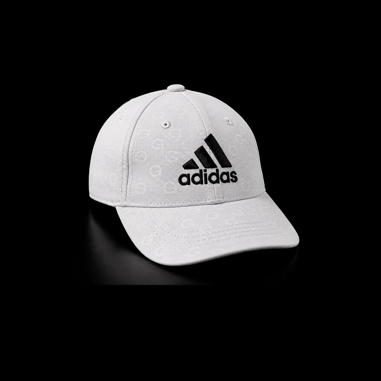 A white Adidas baseball cap with a black embroidered logo on the front, set against a solid black background.