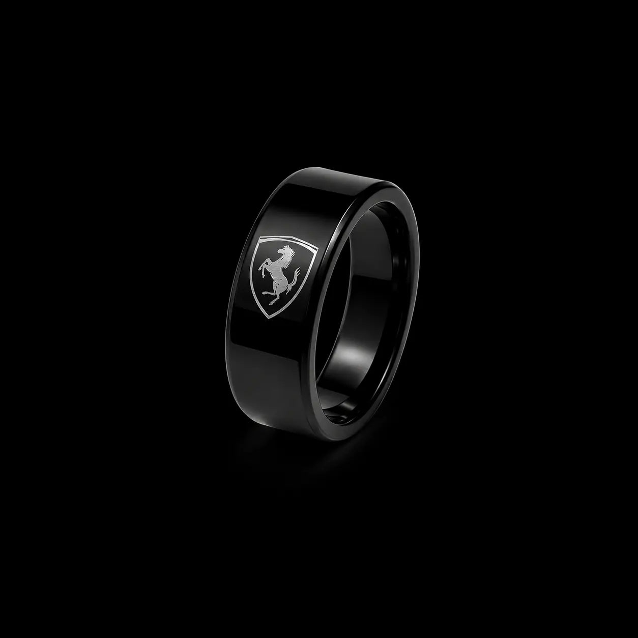 A glossy black ring featuring the silver Ferrari shield logo on the front, set against a solid black background.