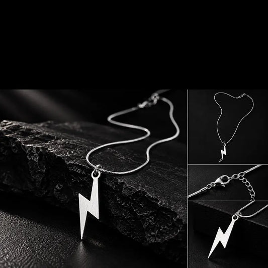 Silver lightning bolt pendant on a snake chain resting on black stone