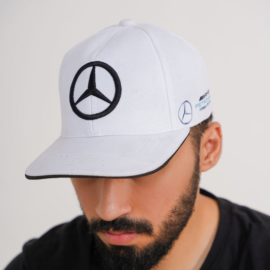 Person wearing a white cap with Mercedes-Benz logo on a plain background