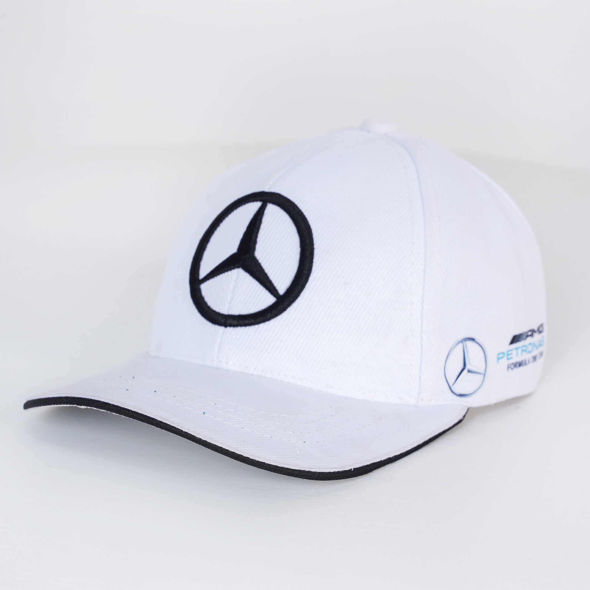 White cap with Mercedes-Benz logo on a light gray background