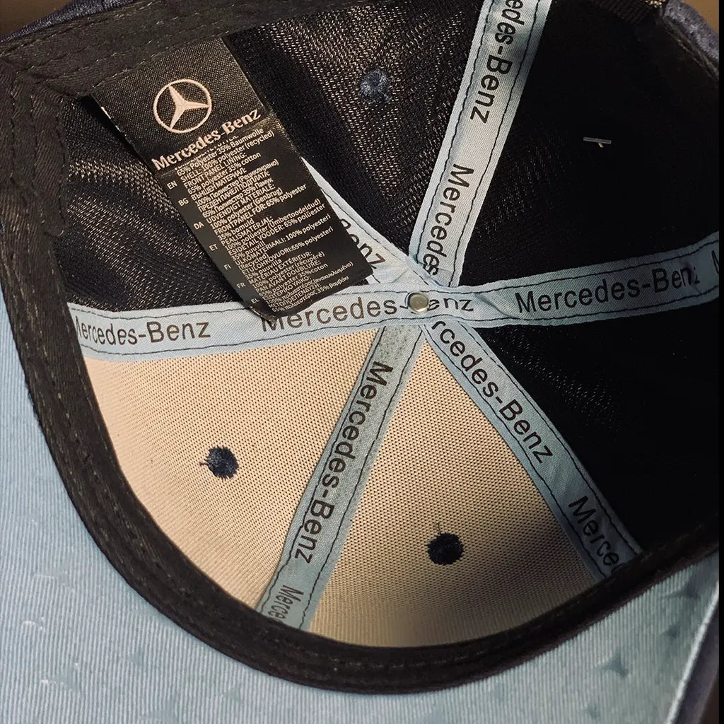 Close-up of a Racing Collection-Benz cap with branding on the brim.