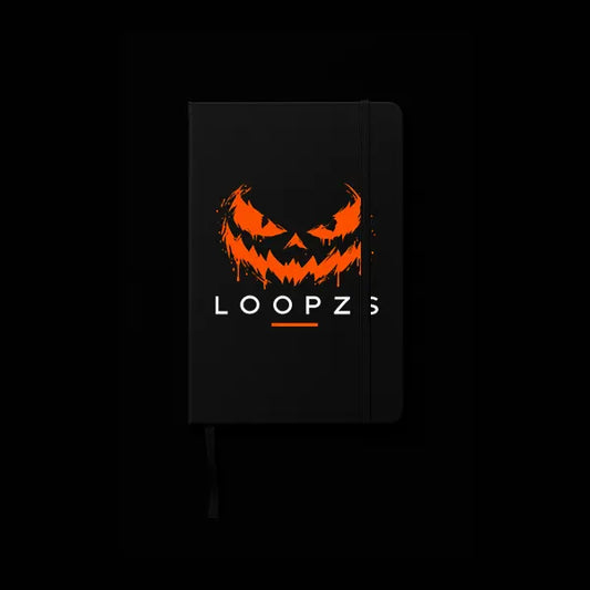 Black A5 notebook with glowing orange dripping pumpkin face and Loopzs wordmark on the cover, elastic band and ribbon bookmark