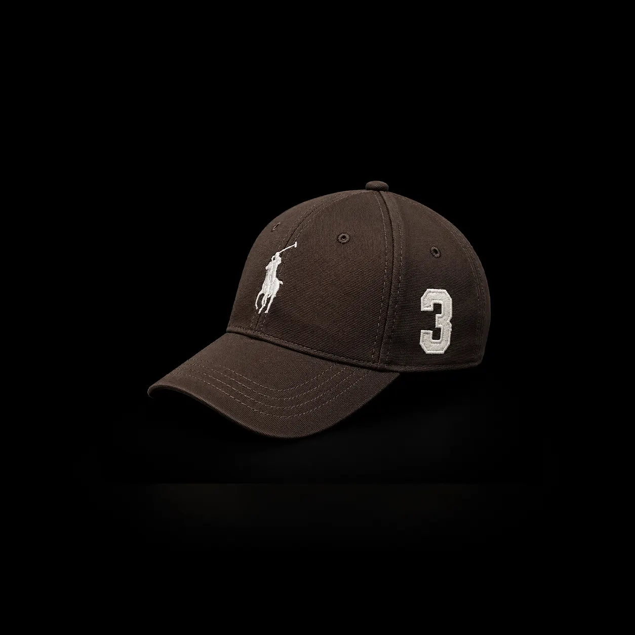 A dark brown baseball cap featuring a white embroidered Polo Ralph Lauren pony logo on the front and the number '3' on the side, set against a solid black background.
