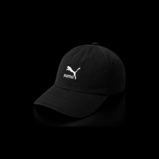 A black Puma baseball cap with a white embroidered Puma logo on the front, set against a solid black background.