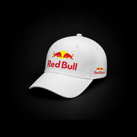 A white baseball cap featuring the Red Bull logo embroidered on the front and side, set against a solid black background.