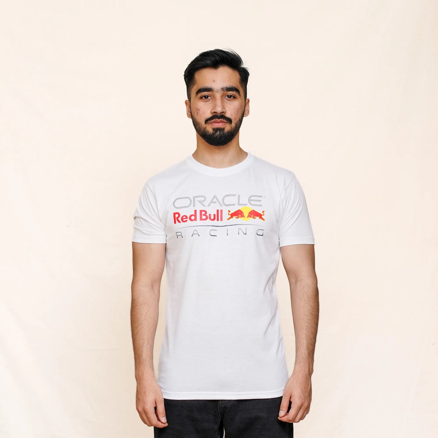 Person wearing a white 'Oracle Red Bull Racing' t-shirt on a beige background