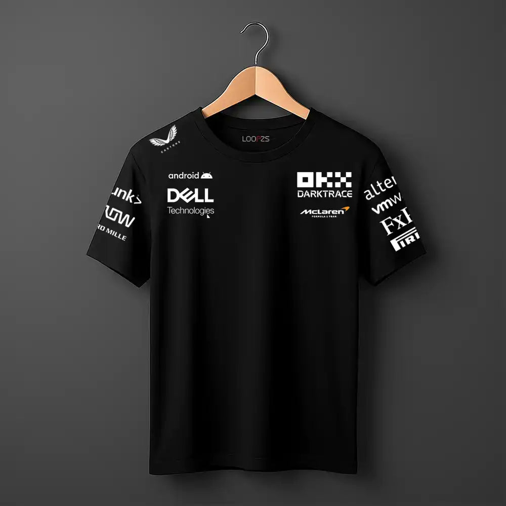 Black t-shirt with various logos on a hanger against a dark background