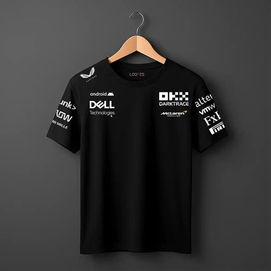 Black t-shirt with various logos on a hanger against a dark background